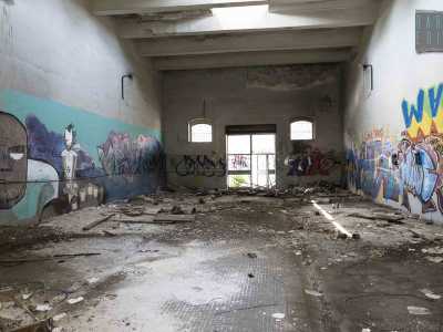 Entriamo in un capannone dedicata all�artigliere Adolfo Dal Piano, morto in Guerra nel 1940. E anche qui troviamo ovunque  rifiuti, macerie, graffiti e distruzione